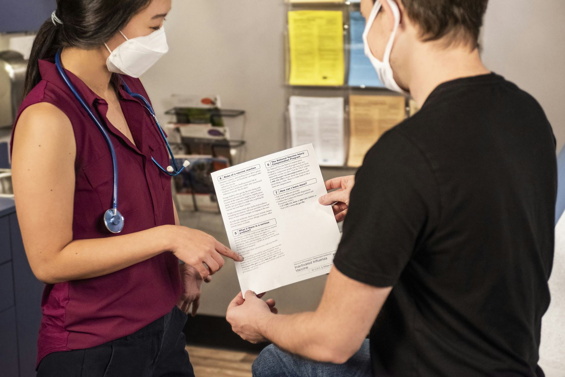 a patient handing a form to a clincian